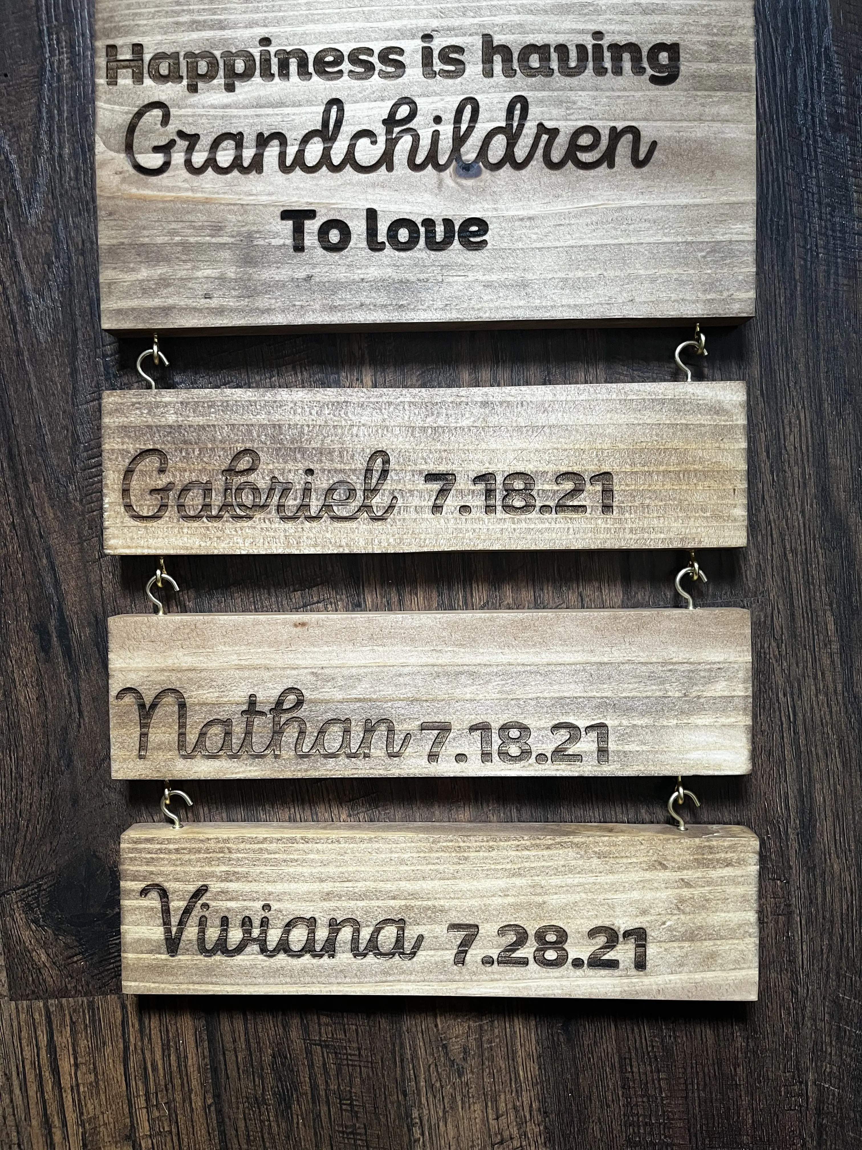 A wooden sign with childrens' names on it.